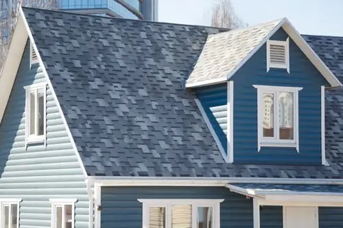 Blue-sided home with a dark shingle roof